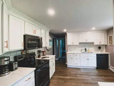 a kitchen with white cabinets and black appliances at Centrally Located - 3 Br House in Southington