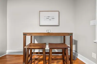 a wooden table with two stools in a room at Spacious Cozy 3 Bed 2 Bath in Southington