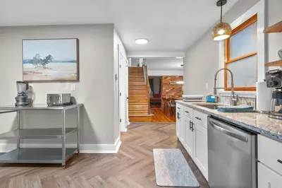a kitchen with stainless steel appliances and wood floors at Spacious Cozy 3 Bed 2 Bath in Southington