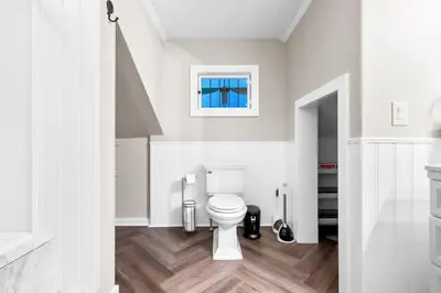 a bathroom with a white toilet and a window at Spacious Cozy 3 Bed 2 Bath in Southington