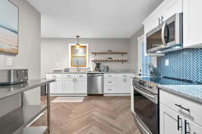 a large white kitchen with white cabinets and appliances at Spacious Cozy 3 Bed 2 Bath in Southington
