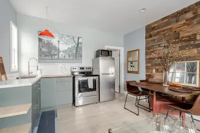 a kitchen with a table and a stainless steel refrigerator at Main Street cabin in Millerton