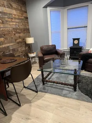 a living room with a glass coffee table and chairs at Main Street cabin in Millerton