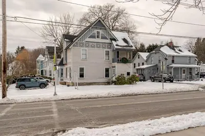 a house on the side of a street with snow at Main Street cabin in Millerton