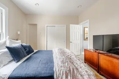a bedroom with a large bed and a tv at Main Street cabin in Millerton