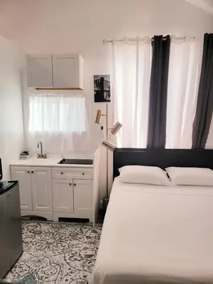 a bedroom with two beds and a kitchen with a sink at Private studio guesthouse in Watertown CT in Watertown