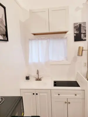 a white kitchen with a sink and a window at Private studio guesthouse in Watertown CT in Watertown