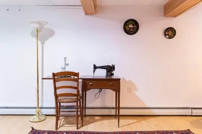 a table with a sewing machine and a chair at Charming home - views of Hunter Mountain slopes in Hunter
