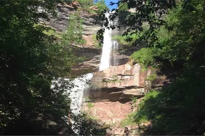 a waterfall on the side of a mountain with trees at Charming home - views of Hunter Mountain slopes in Hunter