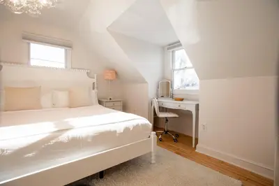 a white bedroom with a bed and a desk at Renovated Cape Near Beach with Fire Pit in Fairfield