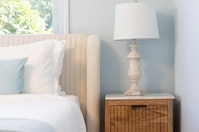 a white lamp on a night stand next to a bed at Renovated Cape Near Beach with Fire Pit in Fairfield
