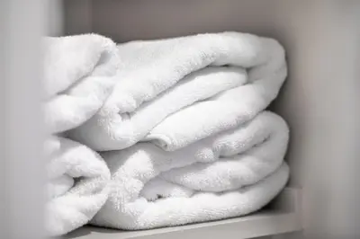a pile of white towels sitting on a shelf at Renovated Cape Near Beach with Fire Pit in Fairfield