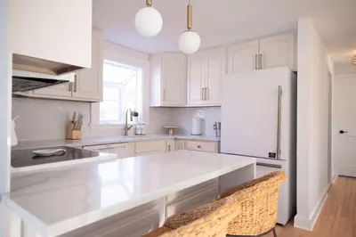 a kitchen with white cabinets and a white refrigerator at Renovated Cape Near Beach with Fire Pit in Fairfield