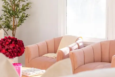 a living room with two couches and a table with roses at Renovated Cape Near Beach with Fire Pit in Fairfield