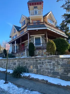 a large house on a stone wall with a no parking sign at Grand 2BR near MetroNorth with easy parking in Yonkers