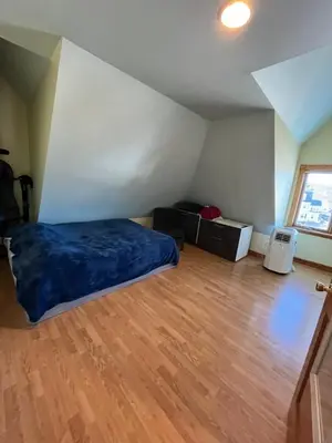 a bedroom with a bed and a wooden floor at Grand 2BR near MetroNorth with easy parking in Yonkers