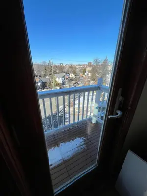 a door open to a balcony with snow on the floor at Grand 2BR near MetroNorth with easy parking in Yonkers