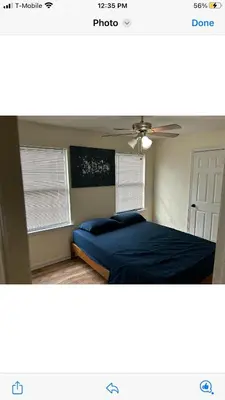 a bedroom with a blue bed and a ceiling fan at Luxury Townhouse in Newark in Newark