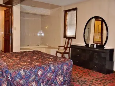 a bedroom with a bed and a mirror and a dresser at Countryside Motel in Fishkill