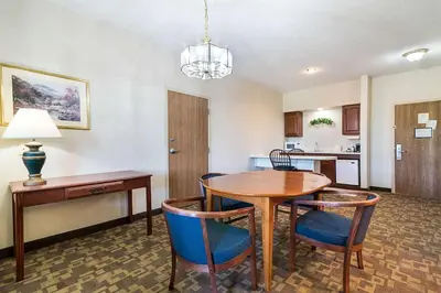 a dining room with a table and chairs and a kitchen at Quality Inn & Suites Schoharie near Howe Caverns in Schoharie