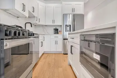 a kitchen with white cabinets and stainless steel appliances at Modern Luxury 3BR 2BA 10 minutes to NYC in Weehawken