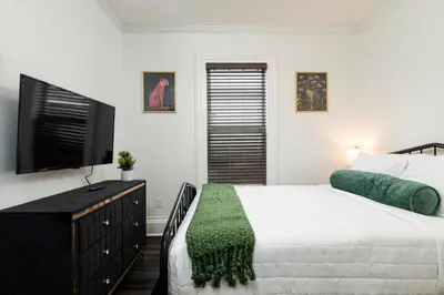 a bedroom with a bed and a flat screen tv at Fully-stocked Kitchen, AC, WiFi, WD, Near Baseball and Downtown in Oneonta
