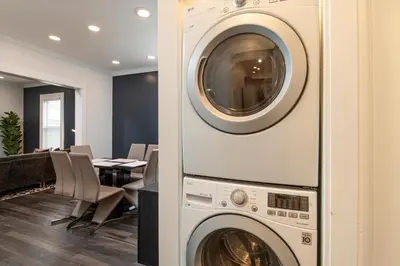 a washer and dryer in a room with a table at Fully-stocked Kitchen, AC, WiFi, WD, Near Baseball and Downtown in Oneonta