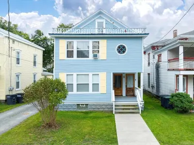 a blue and yellow house in a yard at Fully-stocked Kitchen, AC, WiFi, WD, Near Baseball and Downtown in Oneonta