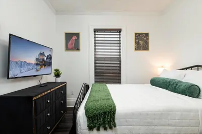 a bedroom with a bed and a flat screen tv at Fully-stocked Kitchen, AC, WiFi, WD, Near Baseball and Downtown in Oneonta
