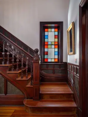 a wooden staircase with a stained glass window at The Grand - The Nicest House in Newburgh in Newburgh