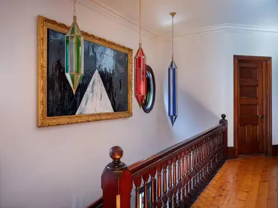 a hallway with a staircase with paintings on the wall at The Grand - The Nicest House in Newburgh in Newburgh