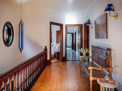 a hallway with a wooden staircase and a room with a bed at The Grand - The Nicest House in Newburgh in Newburgh