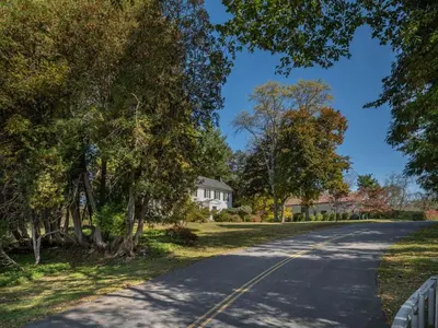 a road with trees on the side of a house at Willow Vale - Stunningly Designed Historical Icon with Hot Tub in Pine Plains