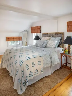 a bedroom with a bed with a blue and white comforter at Willow Vale - Stunningly Designed Historical Icon with Hot Tub in Pine Plains