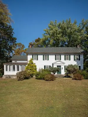 a white house with a metal roof at Willow Vale - Stunningly Designed Historical Icon with Hot Tub in Pine Plains