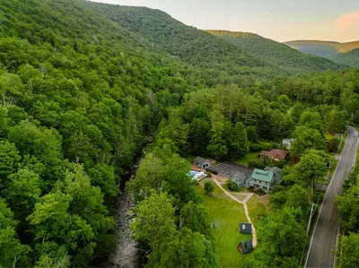 an aerial view of a house in the middle of a forest at The Bend in Phoenicia