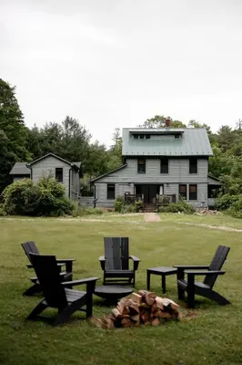 two chairs and a fire pit in front of a house at The Bend in Phoenicia
