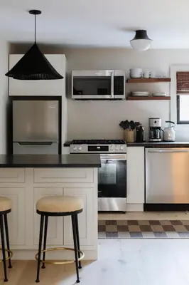 a kitchen with white cabinets and stainless steel appliances at The Bend in Phoenicia