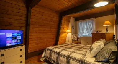 a bedroom with a bed and a flat screen tv at Heaven on Hunter in Hunter
