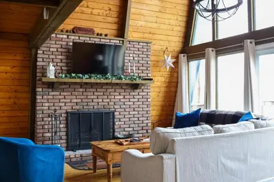a living room with a brick fireplace with a tv at Heaven on Hunter in Hunter