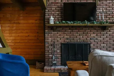 a living room with a brick fireplace and a television at Heaven on Hunter in Hunter
