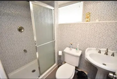 a bathroom with a shower and a toilet and a sink at Cozy home away from home in Tobyhanna