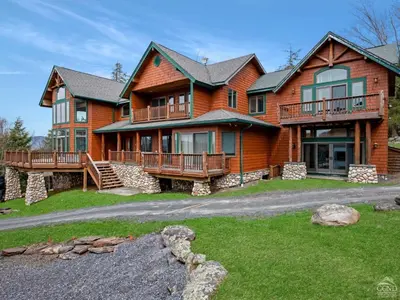 a large wooden house with a porch and balcony at Wintertime in Windham