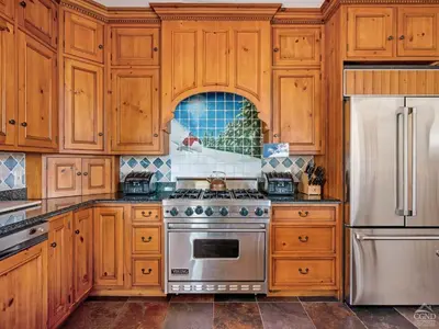 a kitchen with wooden cabinets and a stove and refrigerator at Wintertime in Windham