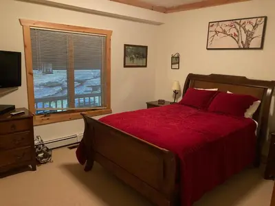 a bedroom with a large red bed and a window at Wintertime in Windham
