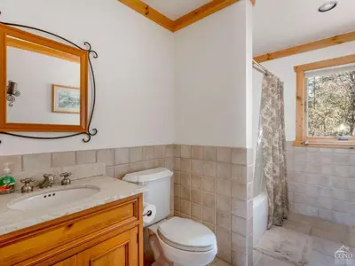 a bathroom with a toilet and a sink and a mirror at Wintertime in Windham