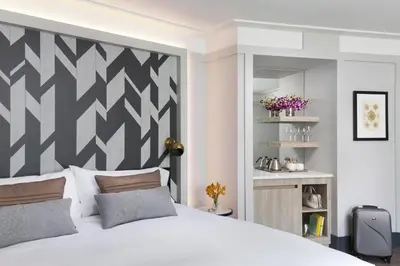 a bedroom with a white bed with a black and white headboard at The Tillary Hotel Brooklyn in Brooklyn