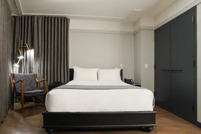 a bedroom with a large white bed and a chair at The Tillary Hotel Brooklyn in Brooklyn