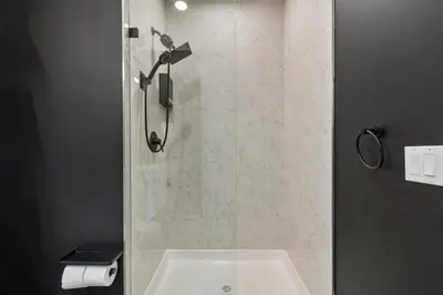 a bathroom with a shower with a white sink at 2BR 2BA, King bd, Gym, Free Parking, 8min to Train in East Orange