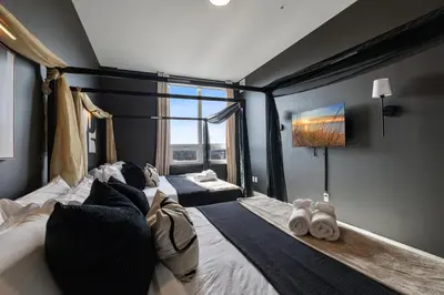 a bedroom with a large bed with a large window at 2BR 2BA, King bd, Gym, Free Parking, 8min to Train in East Orange